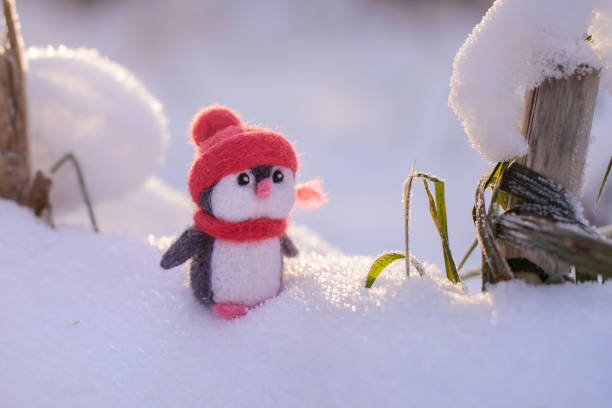 istock Toy wool penguin on a sunny winter day 1290037041