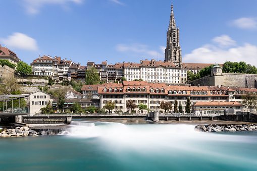 Iconic Cathedral in Bern, UNESCO, Switzerland in spring time with River Aare in foreground and silky water