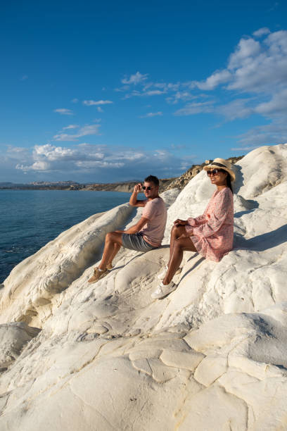 istock Punta Bianca Sicily, couple watching sunset at the white cliffs with abandoned house at Punta Bianca Sicilia Ital 1290038311