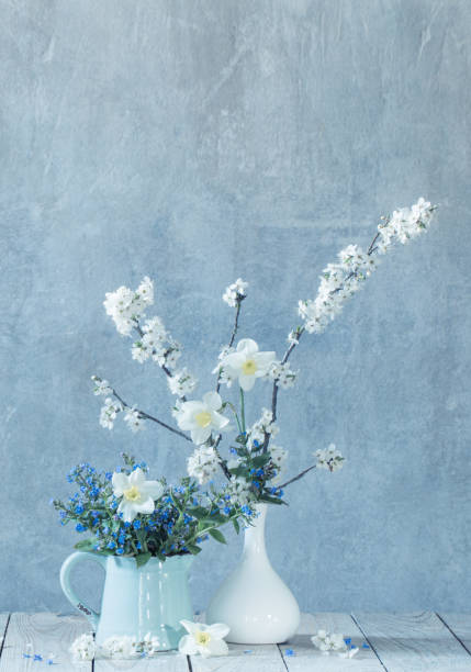 istock spring  flowers in  vases  on background old  wall 1290039034