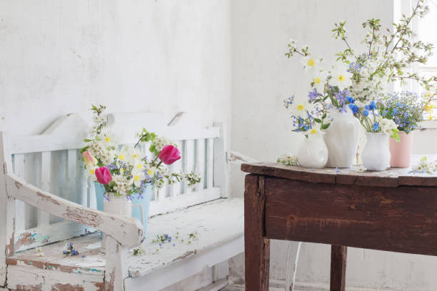 istock spring flowers in vintage white interior with old wooden bench 1290039049