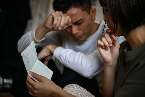 A couple worried while looking at their passbook