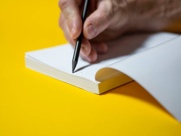 istock Male hand writing in notebook with pen 1290042474