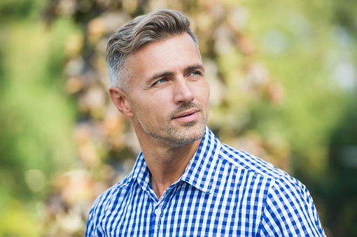 charismatic male has well groomed graying hair, beauty