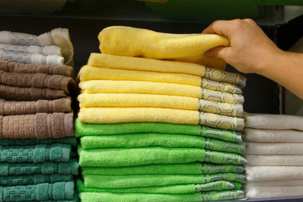 istock A man's hand picks up a yellow towel from a stack on a store shelf 1290048191