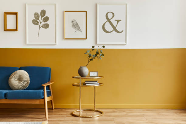 istock Unique living room in modern style interior with design sofa, elegant gold coffee table, mock up poster frames, flowers in vase, decoration and pesronal accessories in home decor. Template. 1290048740
