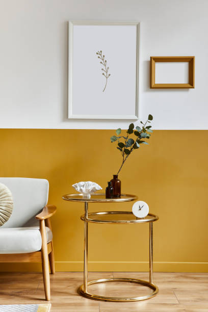 istock Unique living room in modern style interior with design sofa, elegant gold coffee table, mock up poster frames, flowers in vase, decoration and pesronal accessories in home decor. Template. 1290048780