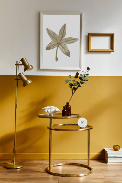 istock Unique living room in modern style interior with design sofa, elegant gold coffee table, mock up poster frames, flowers in vase, decoration and pesronal accessories in home decor. Template. 1290048820