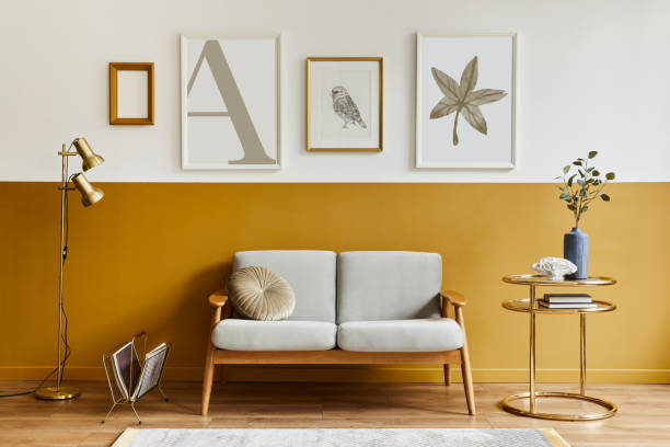 istock Unique living room in modern style interior with design sofa, elegant gold coffee table, mock up poster frames, flowers in vase, decoration and pesronal accessories in home decor. Template. 1290048837