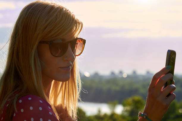 istock Young woman using modern smartphone in urban surroundings. 1290049931