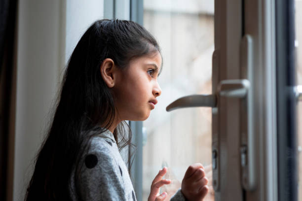 chica joven mirando por la ventana - looking away asian ethnicity child little girls fotografías e imágenes de stock