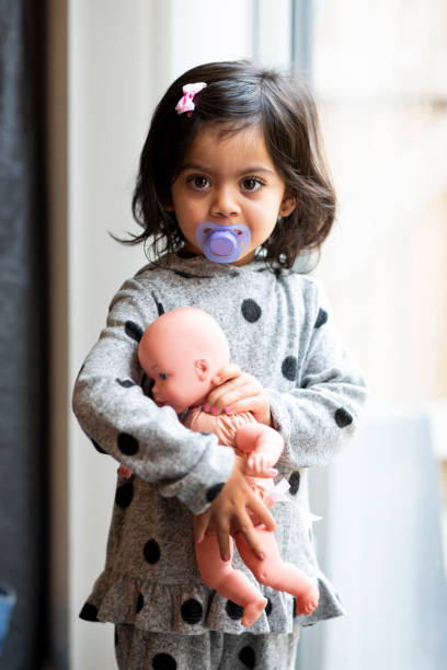 istock Toddler At Home With Her Doll 1290051520