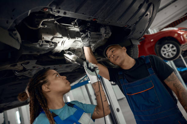 istock Man and girl examining machine raised on lift 1290051594