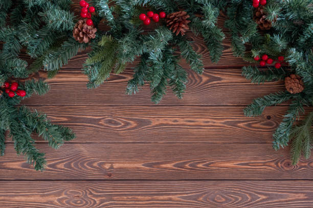 istock Christmas branch on a wooden table with pine cones and red berries 1290055973