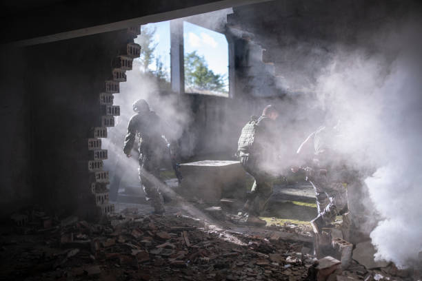 Group of soldiers running from explosion in the building.