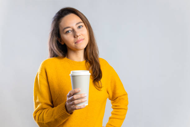 istock Young woman drinking coffee from paper cup 1290065086
