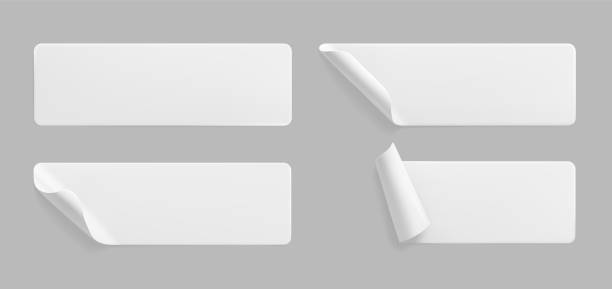 istock White glued rectangle stickers with curled corners mock up set. Blank white adhesive paper or plastic sticker label with wrinkled and creased effect. Template label tags close up. 3d realistic vector 1290065227