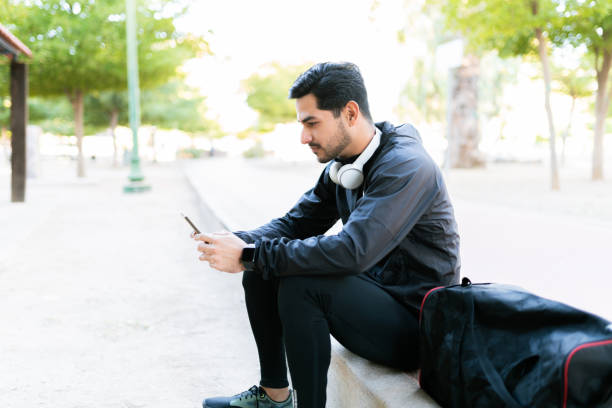 istock Side view of a young man taking a break from exercising in the park 1290065281