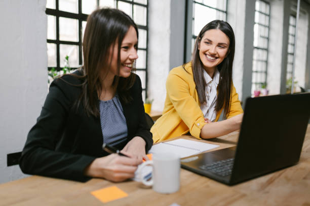 istock Beautiful businesswomen using laptop in modern office 1290067388