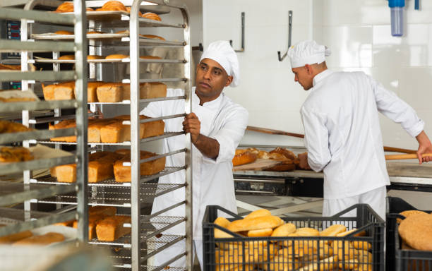 istock male baker with bread in baking shovel and cart in kitchen 1290067794