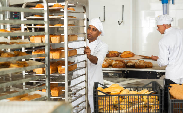 istock male baker with bread in baking shovel and cart in kitchen 1290067797