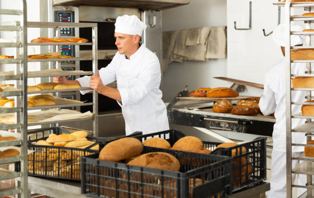 istock Man transporting cart with bread in bakery 1290067801