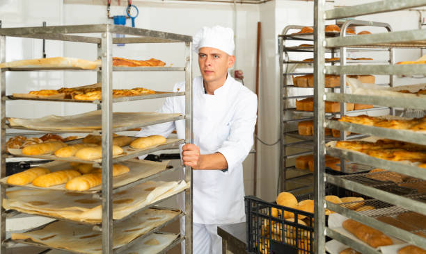 istock Man baker moves cart with prepared pastries 1290067814