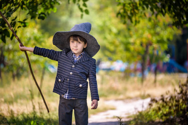 istock Toddler boy in pointed hat playing with magic wand outdoors. Little wizard. Halloween concept 1290068291