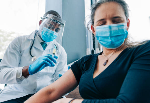 istock Scared woman with eyes closed during vaccination 1290068960