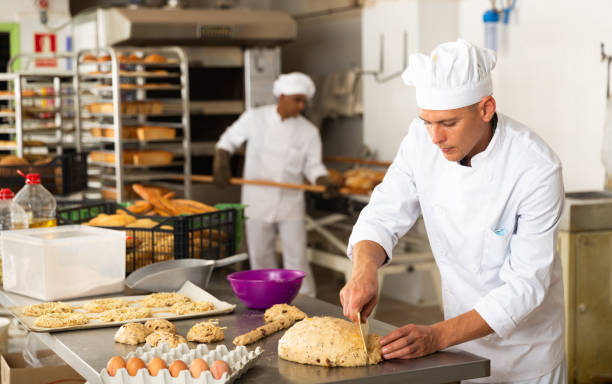 istock Concentrated baker preparing sweet buns in bakery 1290069002