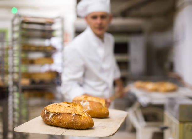 istock Freshly baked bread on peel in bakery 1290069061