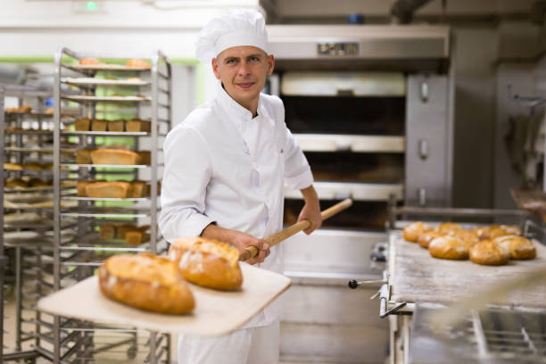 istock man in chefs uniform with bread on shovel in bakehouse 1290069063
