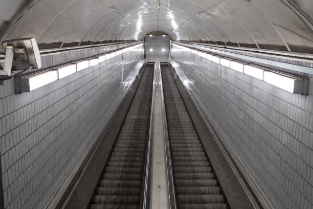 istock Bright lights leading down super long escalator leading to underground subway station 1290070093