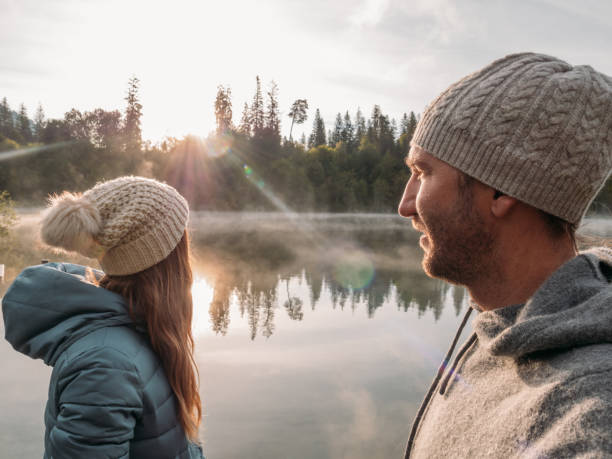 istock Couple relax on lake pier at sunrise 1290074220