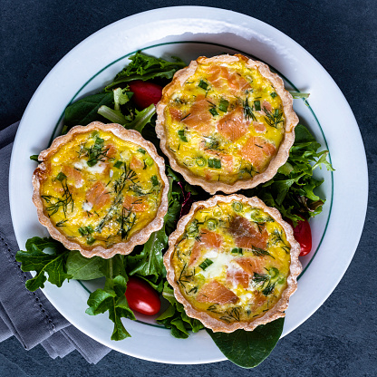 Mini-quiches with smoked salmon, dill, gruyere cheese, and green onions.