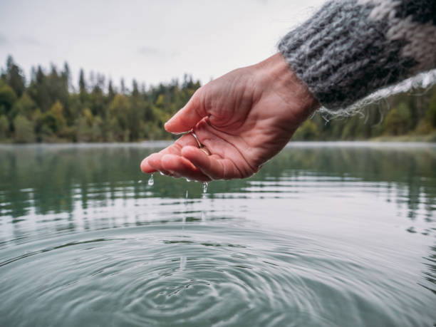 istock Hands scooping water from alpine lake 1290076823