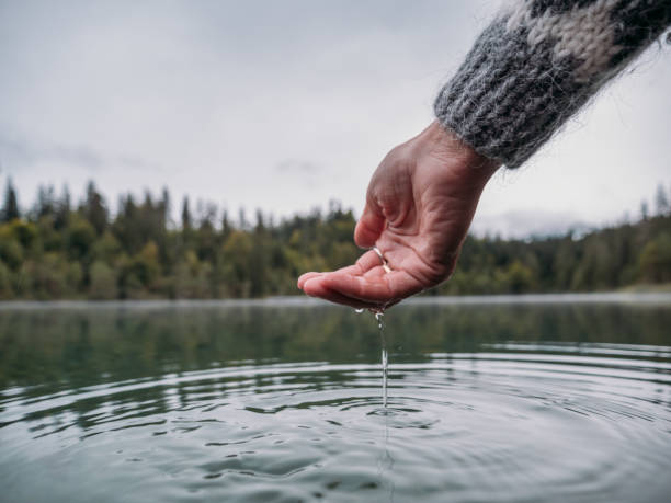 istock Hands scooping water from alpine lake 1290078369
