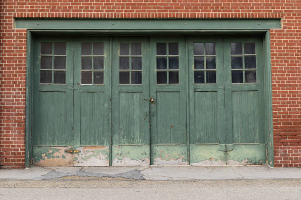 istock Red brick wall with weathered green garage doors, exterior architectural details, creative copy space 1290079529