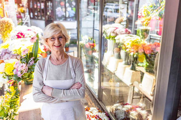istock Happy mature florist posing in her reopened store 1290080376