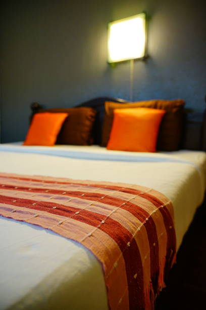 istock Close-up Bedroom Interior with Orange and Brown Pillow 1290080504