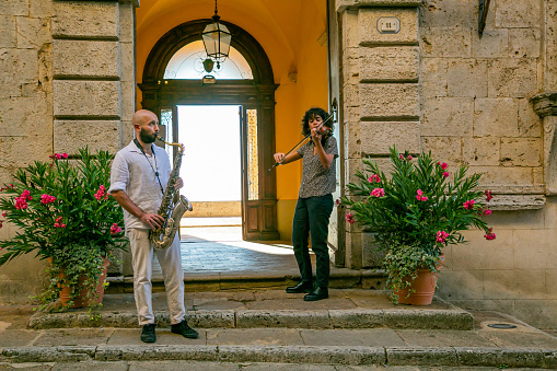 Montepulciano,Tuscany,Italy 04 September 2020:Two musicians play in front of a door in Montepulciano