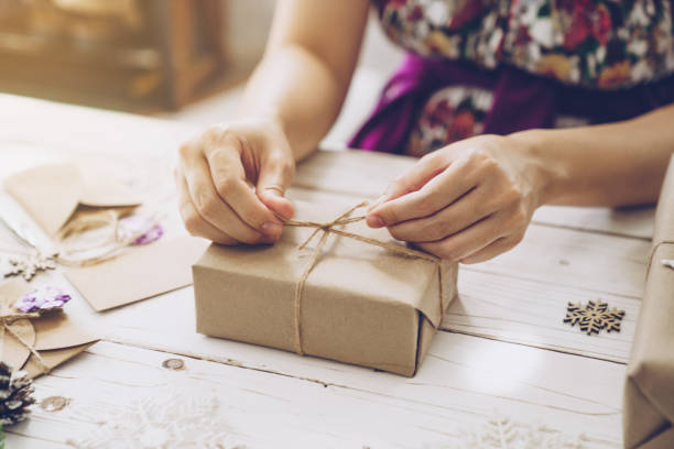istock Woman hand making beautiful Christmas gift box at table 1290081743