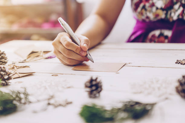 istock Woman hand writing beautiful Christmas card at table 1290081982