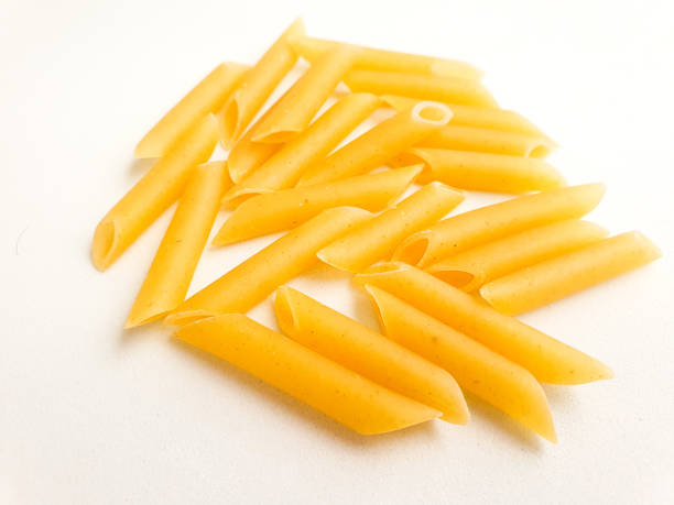 istock Penne pasta isolated. Raw macaroni isolated on white background. 1290084499