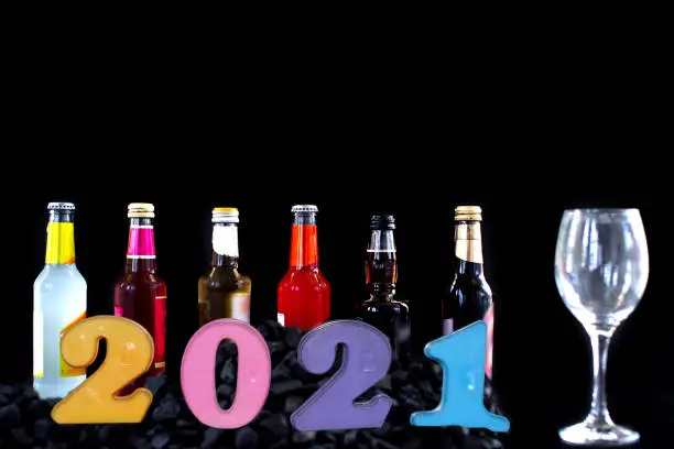 Photo of Number 2021 and bottle of Liquor and Beer with a glass Blurred on a dark background