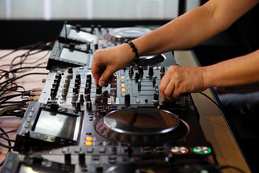 Playing music with DJ mixer controller. Selective focus.