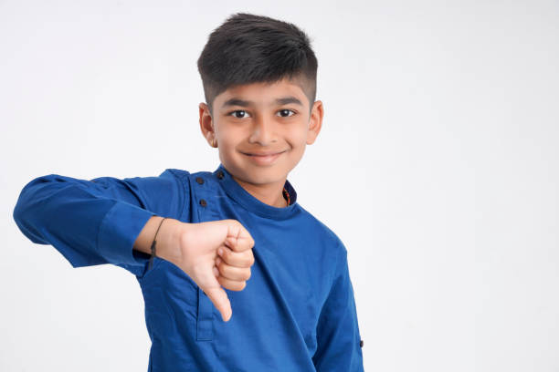 istock Cute little boy with thump down gesture on white background 1290088309