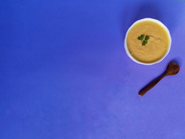 istock Vegetarian autumn pumpkin cream soup on blue background 1290088323