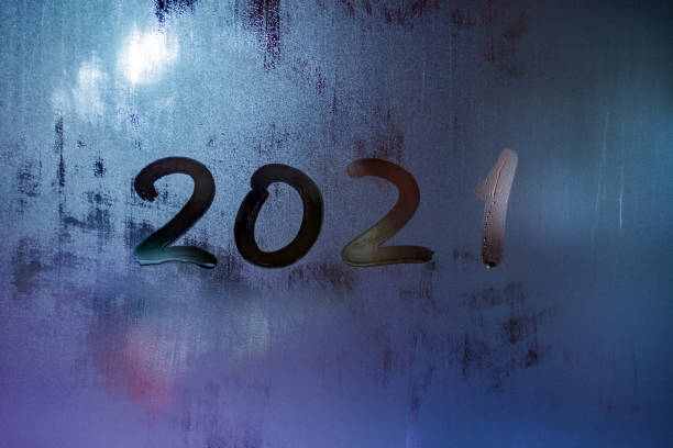 istock digit 2021 handwritten on wet night window glass surface 1290088987