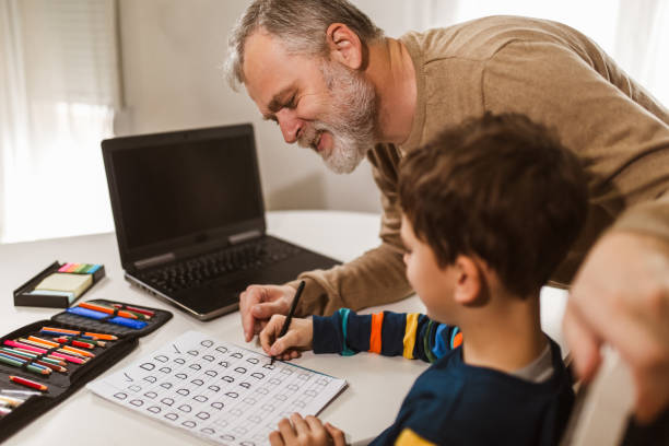 istock Child practicing writing at home with the help of his father 1290090318